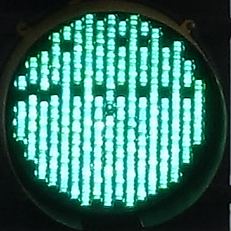 a green signal light wth some dark pixels in alternating columns; location: Elm Street near Davis Square, Somerville, MA