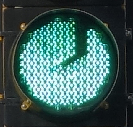 green traffic light with a J-shaped dark scar; location: Highland Ave, Somerville MA