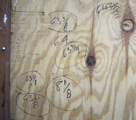 plywood panel with seven measurements in crayon or magic marker